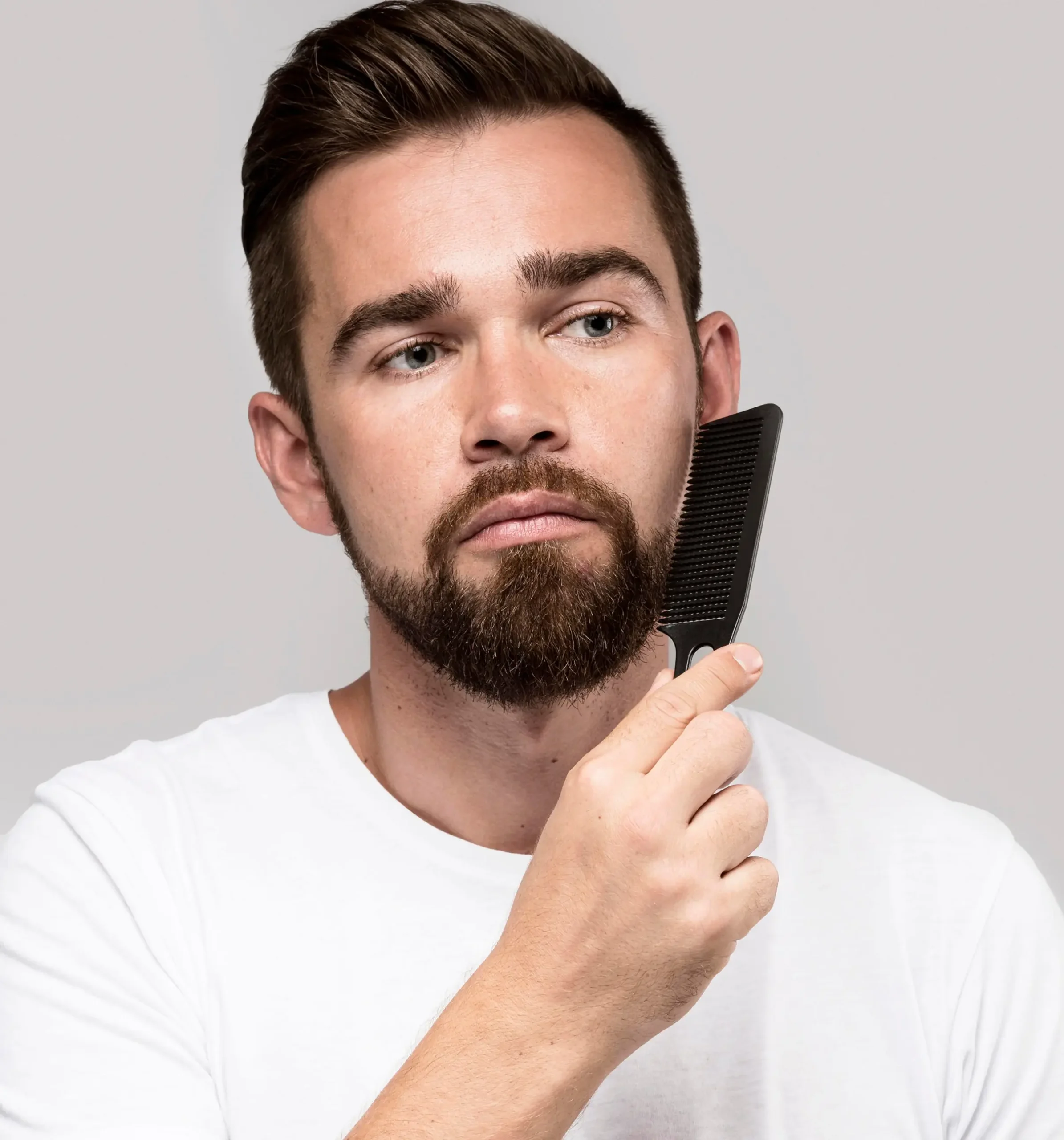 Man brushing beard.